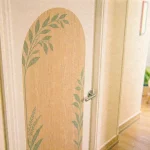 Décoration porte intérieure : grand sticker effet bois clair sur porte blanche